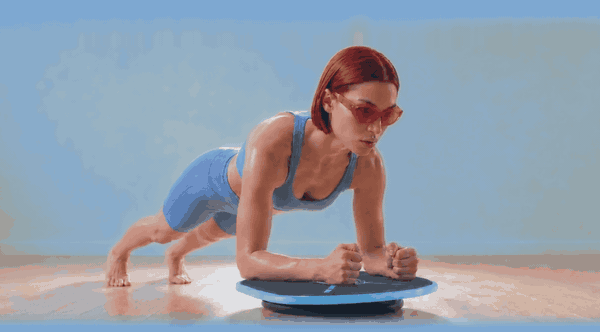 Holding a forearm plank on the board while it tilts underneath