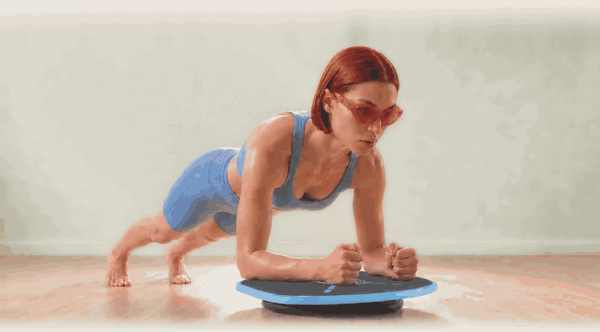 Holding a forearm plank on the board while it tilts underneath